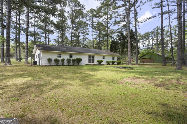 back of property with fence, a yard, and central air condition unit