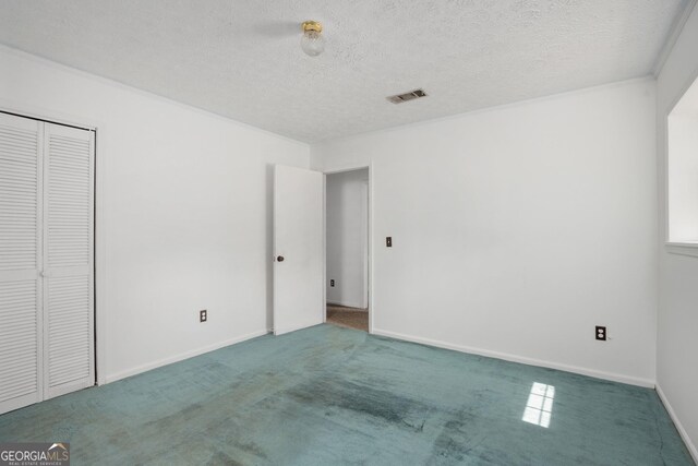 unfurnished bedroom with baseboards, visible vents, carpet floors, and a textured ceiling
