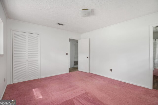 unfurnished bedroom featuring carpet, visible vents, baseboards, and a textured ceiling
