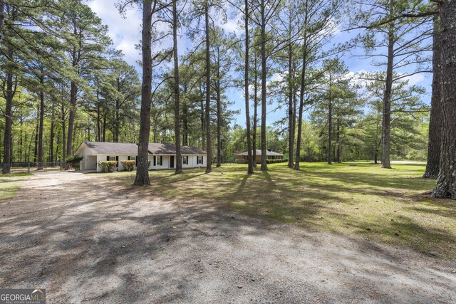 view of front of property with a front yard, driveway, and fence