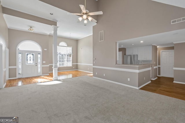 unfurnished living room featuring visible vents, ornate columns, ornamental molding, and baseboards