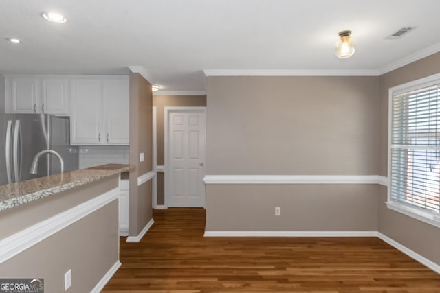 kitchen featuring a wealth of natural light, visible vents, freestanding refrigerator, and white cabinetry