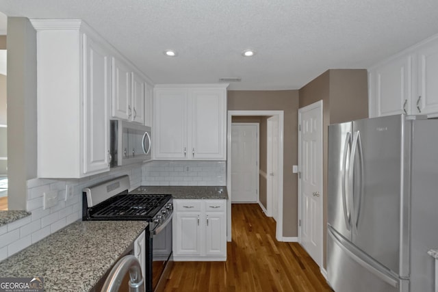 kitchen featuring white cabinetry, stainless steel appliances, and dark wood finished floors