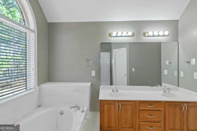 full bath featuring a bath, double vanity, and a sink