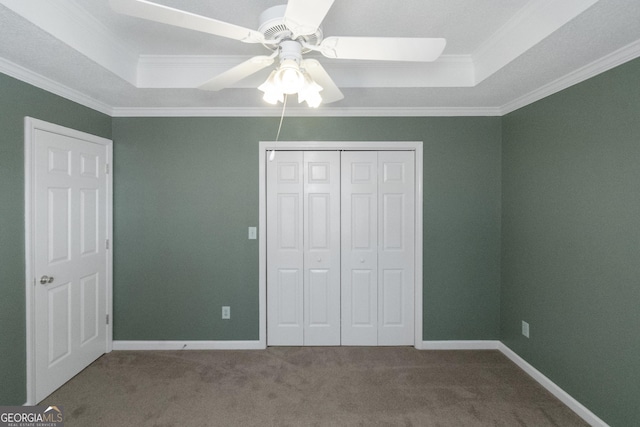 unfurnished bedroom featuring crown molding, carpet, and a tray ceiling