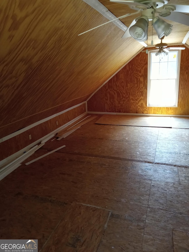 bonus room featuring ceiling fan, wood walls, and lofted ceiling