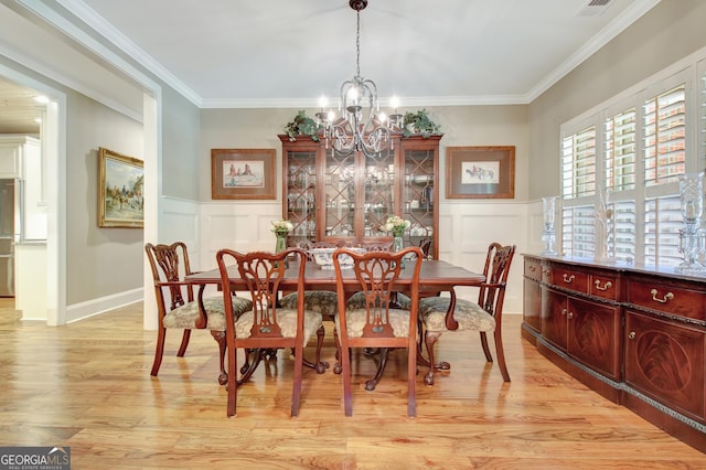 53 Gordon Manor Ct, Senoia, GA 30276 - dining space with a chandelier, a decorative wall, light wood-style floors, wainscoting, and crown molding
