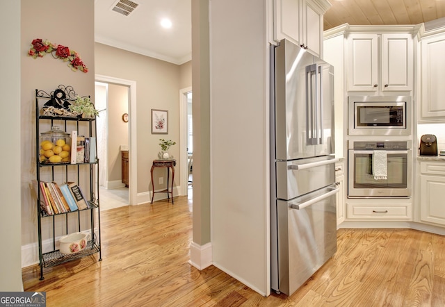 53 Gordon Manor Ct, Senoia, GA 30276 - kitchen featuring appliances with stainless steel finishes, light wood-style floors, white cabinets, ornamental molding, and recessed lighting