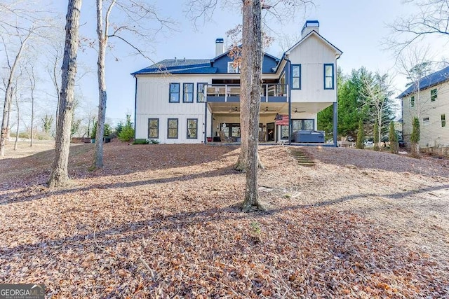 6014 Warpath Rd, Flowery Branch, GA 30542 - back of property with a carport, a chimney, driveway, a balcony, and board and batten siding