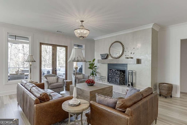 6014 Warpath Rd, Flowery Branch, GA 30542 - living room featuring crown molding, light wood-style floors, a fireplace, a chandelier, and french doors