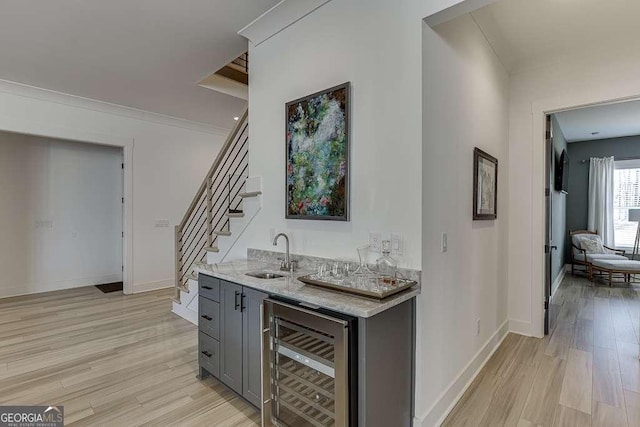 6014 Warpath Rd, Flowery Branch, GA 30542 - indoor wet bar with wine cooler, light wood finished floors, stairway, and baseboards