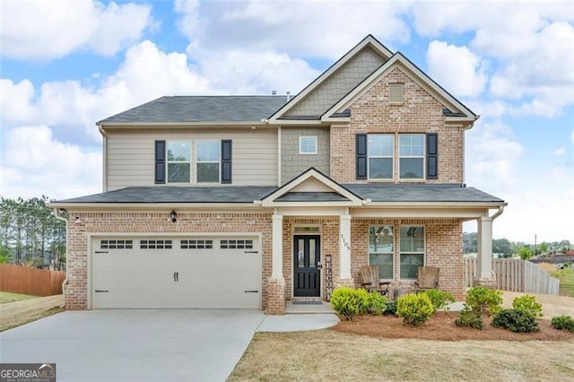 craftsman inspired home with fence, concrete driveway, a porch, brick siding, and a garage