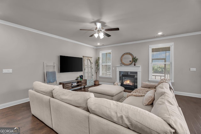 living room featuring visible vents, baseboards, a premium fireplace, ceiling fan, and crown molding