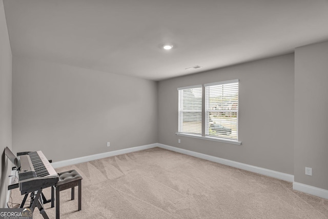 unfurnished room featuring light carpet, visible vents, and baseboards