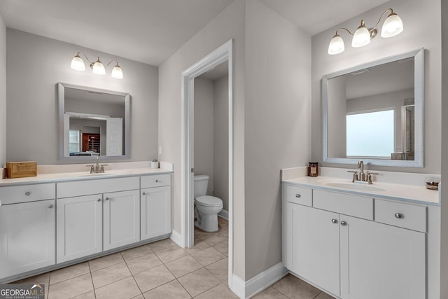 bathroom featuring two vanities, a sink, and toilet