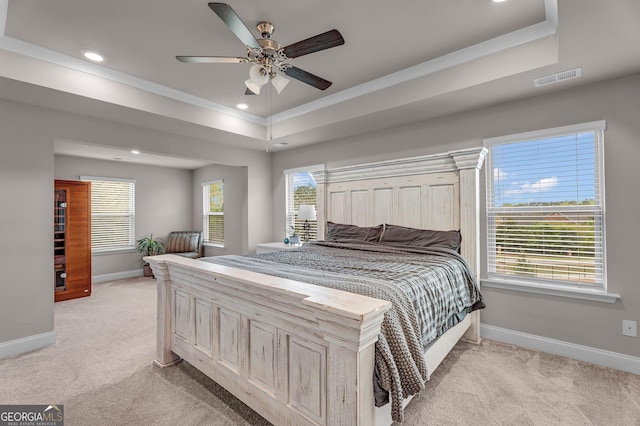 bedroom with recessed lighting, a tray ceiling, visible vents, baseboards, and light colored carpet