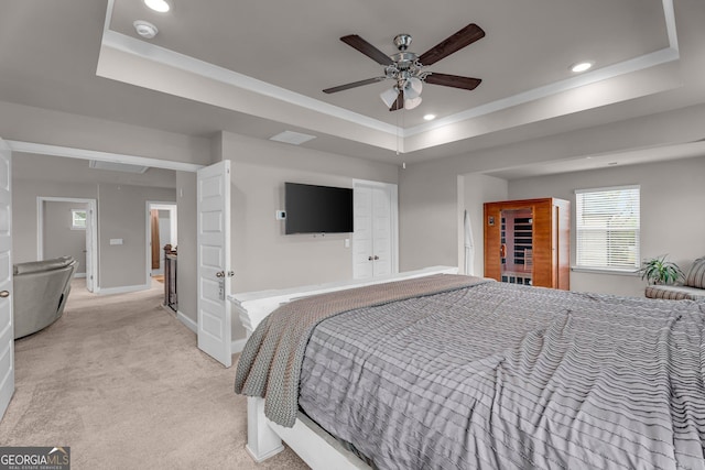 bedroom with light carpet, a tray ceiling, baseboards, recessed lighting, and a ceiling fan