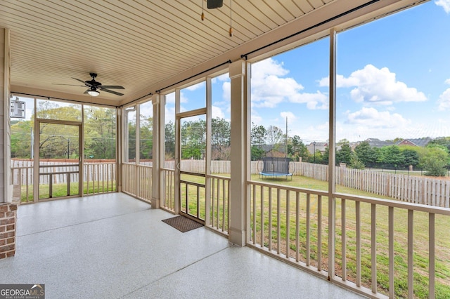 unfurnished sunroom with a ceiling fan