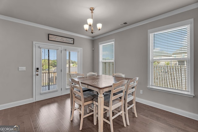 dining space featuring baseboards, visible vents, an inviting chandelier, dark wood-type flooring, and ornamental molding