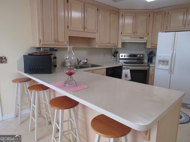 kitchen with black appliances, under cabinet range hood, a sink, light countertops, and a peninsula