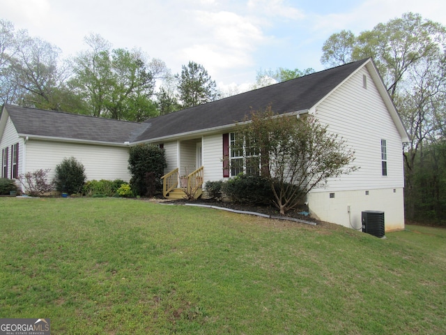 ranch-style house featuring a front yard and central AC unit