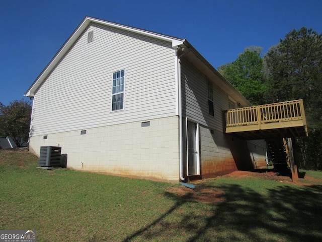 view of side of property featuring a wooden deck, a yard, and central air condition unit