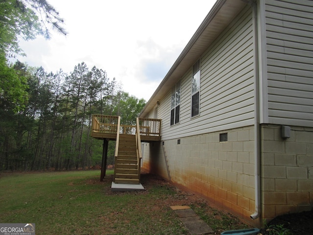 view of side of property featuring stairway, a deck, and a yard