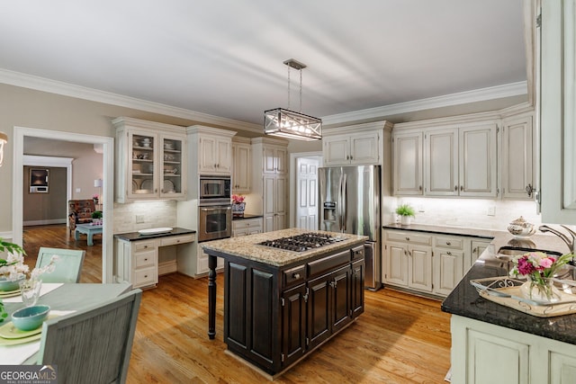kitchen with crown molding, a kitchen island, stainless steel appliances, and decorative backsplash