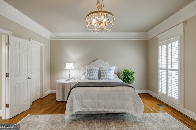 bedroom featuring visible vents, a chandelier, ornamental molding, and baseboards