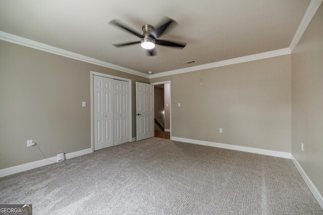 unfurnished bedroom featuring crown molding, carpet flooring, and baseboards