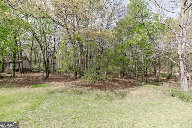 view of yard with fence and a view of trees
