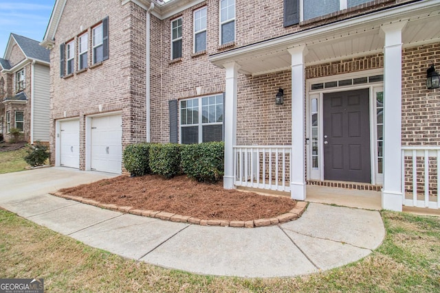 2036 Broadmoor Way, Fairburn, GA 30213 - view of exterior entry with driveway, brick siding, a garage, and covered porch