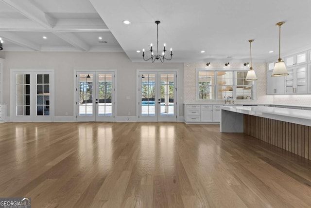 kitchen with white cabinetry, beam ceiling, and light wood-type flooring