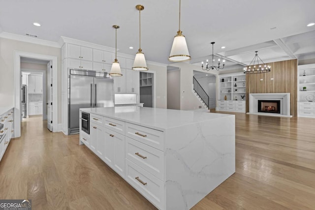 kitchen featuring stainless steel built in refrigerator, visible vents, white cabinets, light wood-style floors, and coffered ceiling