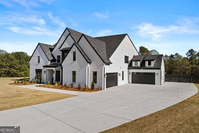 view of front of house featuring concrete driveway, stucco siding, fence, a front lawn, and a garage