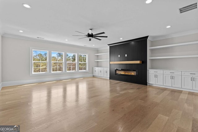 unfurnished living room featuring ornamental molding, light wood-style floors, ceiling fan, and visible vents