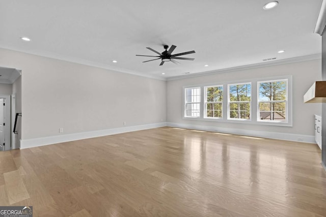 unfurnished living room featuring light wood-type flooring, ornamental molding, baseboards, visible vents, and a ceiling fan