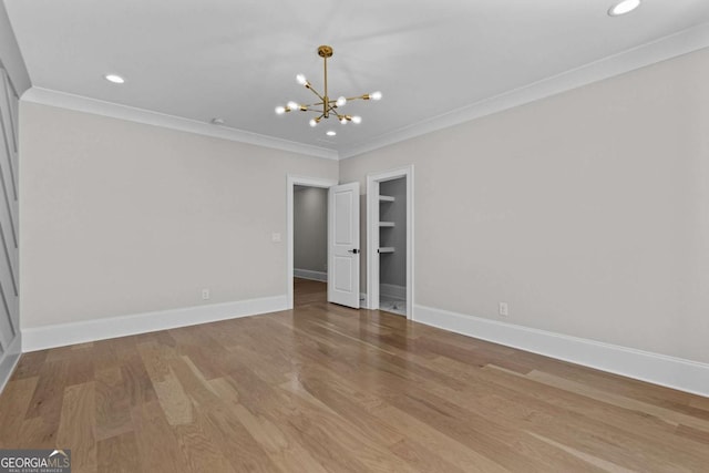 unfurnished room with crown molding, a chandelier, wood finished floors, baseboards, and recessed lighting
