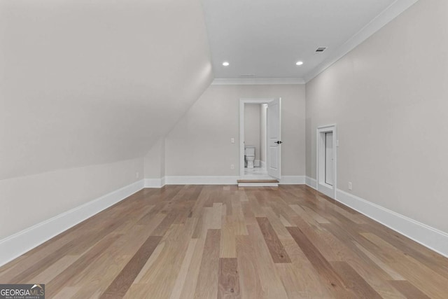 additional living space with vaulted ceiling, wood finished floors, baseboards, visible vents, and recessed lighting