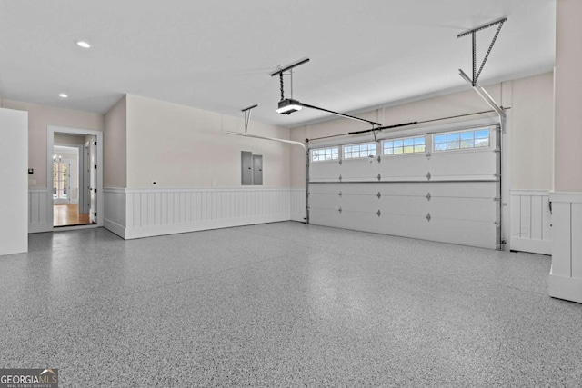 2485 Brooks Rd, Dacula, GA 30019 - garage featuring wainscoting, electric panel, a garage door opener, and recessed lighting