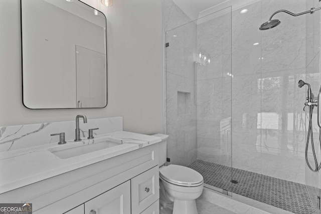 bathroom featuring a stall shower, marble finish floor, toilet, and vanity