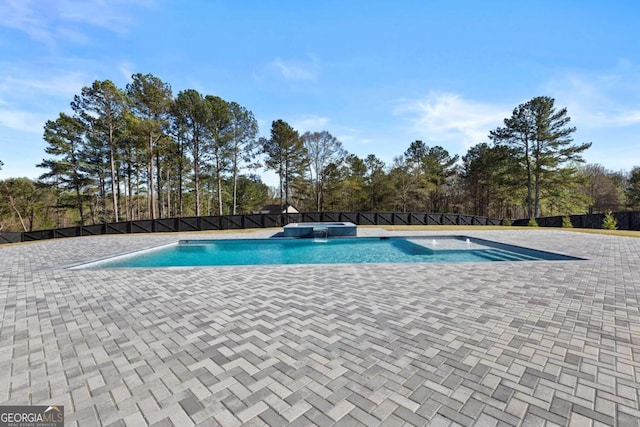 view of swimming pool featuring fence and a pool with connected hot tub