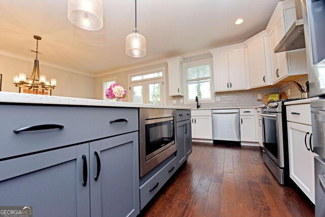 1494 Addison Pl, Decatur, GA 30033 - kitchen featuring stainless steel appliances, hanging light fixtures, dark wood-style flooring, white cabinets, and crown molding
