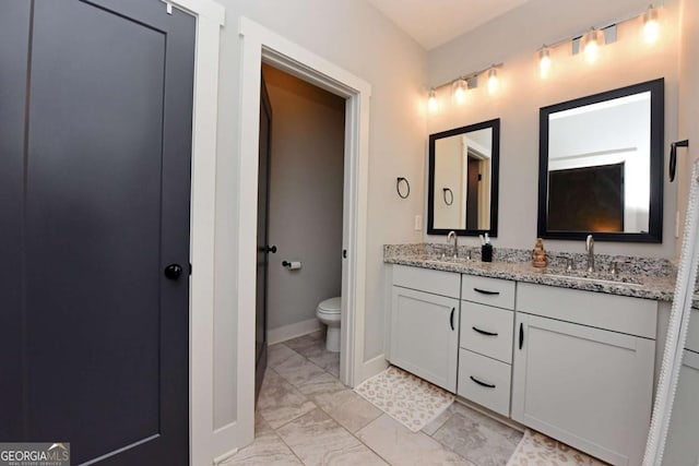 1494 Addison Pl, Decatur, GA 30033 - bathroom featuring marble look tiles, toilet, double vanity, and baseboards