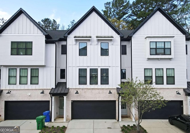 1494 Addison Pl, Decatur, GA 30033 - view of front of home featuring board and batten siding, a garage, concrete driveway, and brick siding