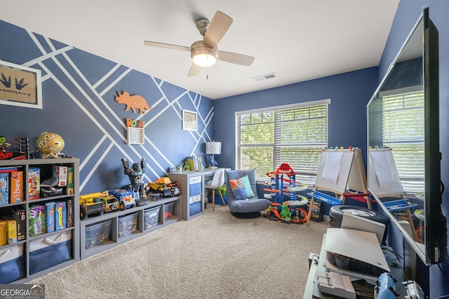 rec room with ceiling fan, carpet flooring, and visible vents