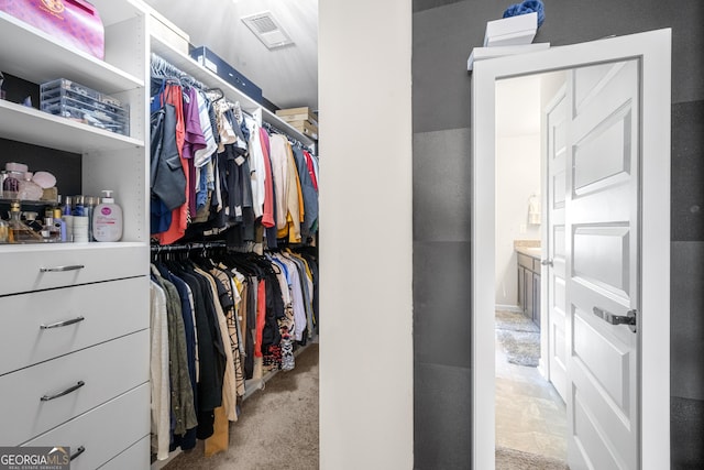 spacious closet with light colored carpet and visible vents
