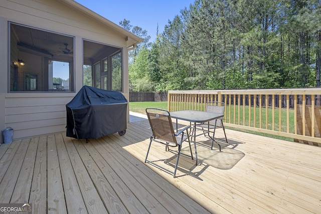 wooden terrace with a yard, fence, grilling area, a sunroom, and outdoor dining area