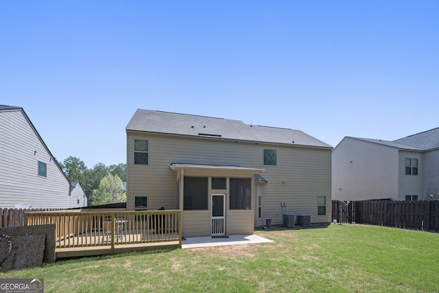rear view of house featuring a fenced backyard, a yard, cooling unit, a sunroom, and a deck