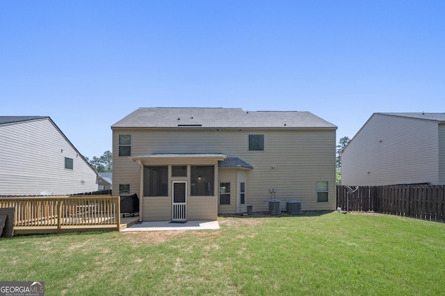 rear view of house featuring a fenced backyard, a sunroom, a patio area, and a yard